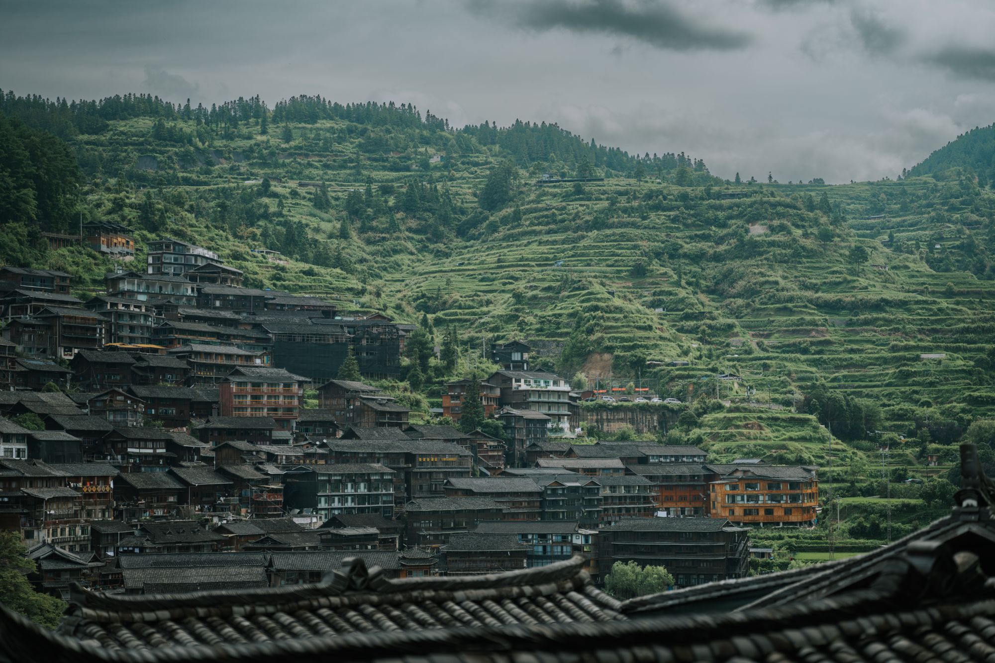 Xijiang Miao Village — stilt houses stacked across a green valley in Guizhou